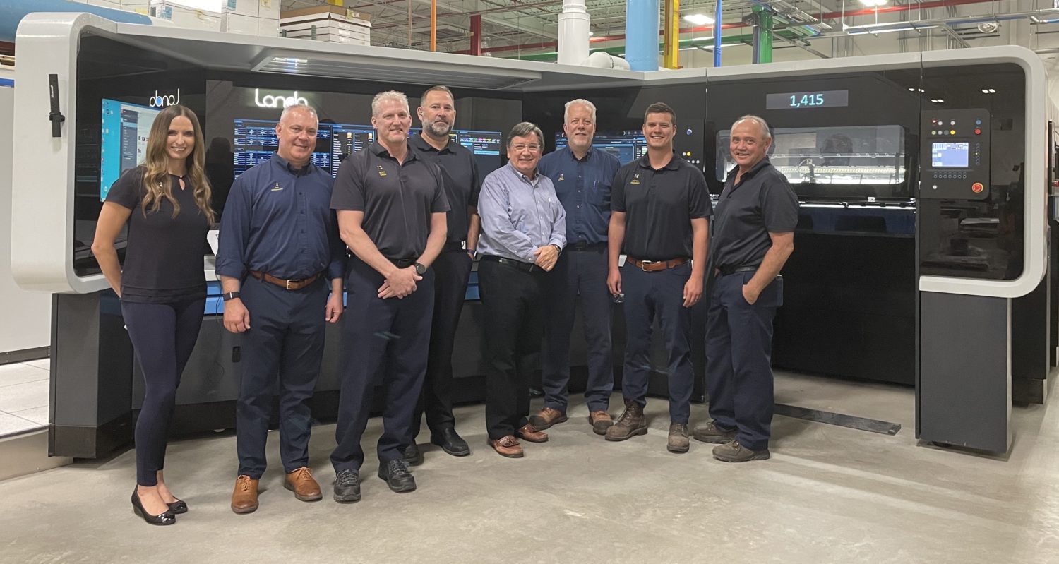 Group of Quad employees in front of Landa Print machinery